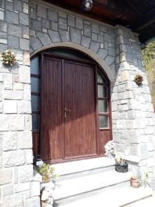 a wooden door on a stone building with stairs at Pensiunea Nick in Sinaia