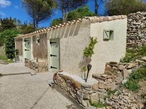- un bâtiment en pierre avec deux portes et un mur en pierre dans l'établissement MaCoCo Maison Coeur Corbieres, à Fontjoncouse