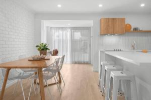 a kitchen with a table and chairs in a kitchen at Vibes At Five Noosa in Noosaville