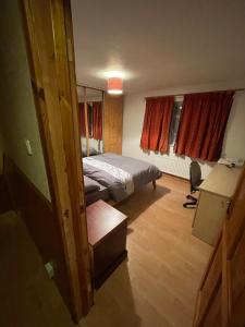 a bedroom with a bed and a desk in it at Lux Homes in Sunbury Common