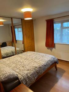 1 Schlafzimmer mit 2 Betten und 2 Fenstern in der Unterkunft Lux Homes in Sunbury Common