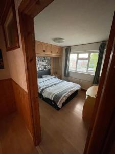 a bedroom with a bed and a window at Lux Homes in Sunbury Common