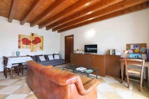 a living room with a brown leather couch and a table at Centro storico Bilocale Check in 24h Wi-Fi Bus 500m in Borgo di Terzo