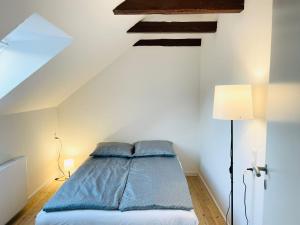 a bedroom with a bed with blue sheets and a ceiling at Scandinavian Apartment Hotel - Lunden 1 - Central 3 bedroom apartment on two floors in Horsens