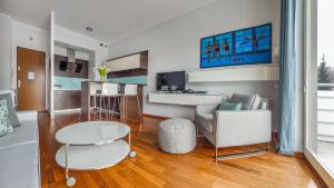 a living room with a table and a chair at Apartamenty Sun & Snow Redłowo in Gdynia