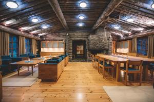 uma sala de jantar com mesas de madeira e cadeiras azuis em Santa's Hotel Aurora & Igloos em Luosto