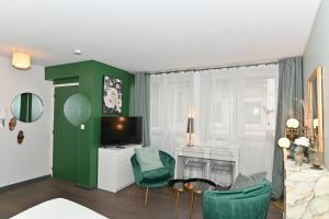 リヨンにあるAppart' Brestのリビングルーム(緑の椅子、テレビ付)