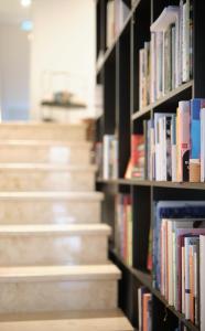 una estantería llena de libros junto a una escalera en Lesehotel, en Bad Goisern