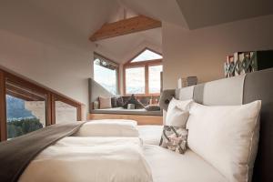 a bedroom with a white bed with a large window at Lesehotel in Bad Goisern