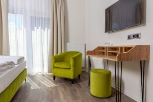 尤特博格的住宿－Hotel Fuchsbau Jüterbog，客房设有一张床、一张桌子和一把椅子。