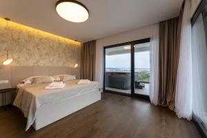 a bedroom with a bed and a large window at Villa Duje in Kastel Stari +44 photos