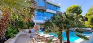 um edifício de apartamentos com piscina e palmeiras em * THE CRYSTAL BAY * Luxury bay and see view Villa em Cala Pi