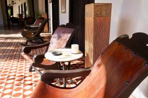 a table and chairs with a cup on top of it at VILLA MERIDA BOUTIQUE HOTEL - Adults Only in Mérida