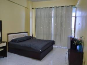 Schlafzimmer mit einem Bett und einem Fenster in der Unterkunft Lagenda Condominium Melaka in Malakka