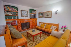 a living room with yellow couches and a fireplace at Casa de Campo Cala Bassa in Sant Josep de sa Talaia