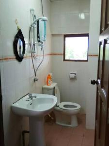 ein Badezimmer mit einem weißen Waschbecken und einem WC in der Unterkunft Lagenda Condominium Melaka in Malakka