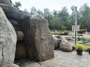 eine große Felsformation in einem Park mit einigen Pflanzen in der Unterkunft Lagenda Condominium Melaka in Malakka
