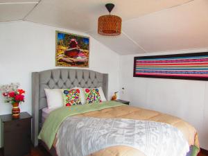 a bedroom with a bed and some pictures on the wall at Titicaca tikary's lodge in Puno