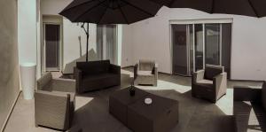 ein Wohnzimmer mit Stühlen und Sonnenschirmen in der Unterkunft Soffio del Salento in Matino