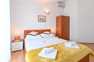 sypialnia z 2 łóżkami i białymi ręcznikami w obiekcie Apartments Andrea I w Bašce