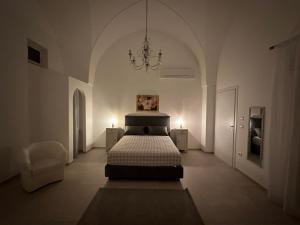 Schlafzimmer mit einem Bett und einem Kronleuchter in der Unterkunft Soffio del Salento in Matino