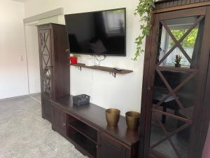 a entertainment center with a flat screen tv on a wall at Casa Andrea Apartment mit Balkon in Wallersdorf