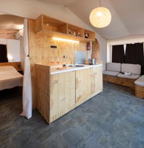 a kitchen with wooden cabinets and a sink in a room at Camping Village Il Gineprino in Marina di Bibbona