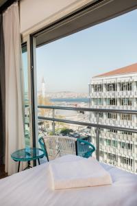 a bedroom with a bed and a large window at Miller Hotel in Istanbul