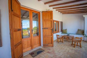 a room with wooden doors and a table with chairs at Casa de Campo Cala Bassa in Sant Josep de sa Talaia