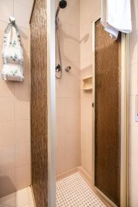 una doccia con porta in legno in bagno di IL MONTE a Erice