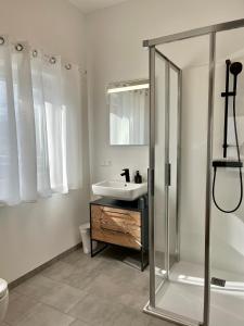 La salle de bains blanche est pourvue d'un lavabo et d'une douche. dans l'établissement Athecada Frühstückspension, à Birkfeld