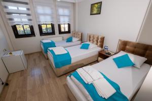 Habitación con 3 camas en una habitación en SULTAN SARAY OTEL, en Safranbolu