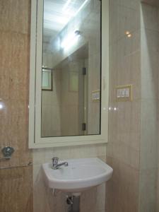 a bathroom with a sink and a mirror at Gladsvilla in Mangalore
