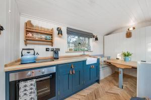 a kitchen with blue cabinets and a sink at Oak + Stars Hideaway in Holmfirth