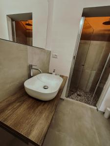 ein Badezimmer mit einem weißen Waschbecken und einer Dusche in der Unterkunft Soffio del Salento in Matino