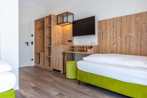 a bedroom with a bed with a wooden wall at Hotel Fuchsbau Jüterbog in Jüterbog