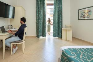 een man aan een bureau met een laptop bij Hotel Centrale Spa & Relax in Alcamo