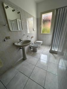 een badkamer met een wastafel, een toilet en een spiegel bij Casa Mario e Rosa in Orosei +6 foto's