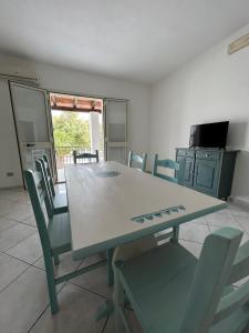 een tafel en stoelen in een kamer met een keuken bij Casa Mario e Rosa in Orosei