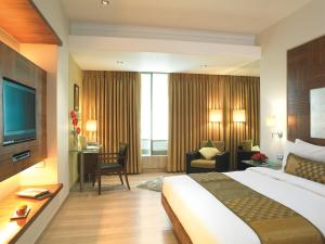 Habitación de hotel con cama grande y escritorio. en Mirage Hotel en Bombay