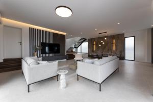 a living room with two couches and a television at Villa Duje in Kastel Stari