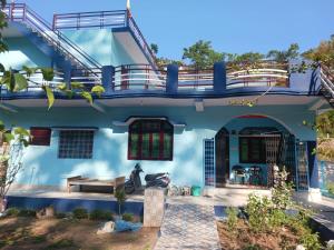a blue house with a staircase on top of it at Somesh Homestay in Uttarkāshi