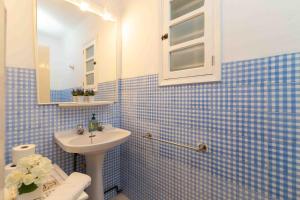 a blue tiled bathroom with a sink and a mirror at Duna in Playa de Muro