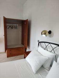 um quarto com uma cama e uma cómoda com um espelho em Tilos Fantasy em Livadia