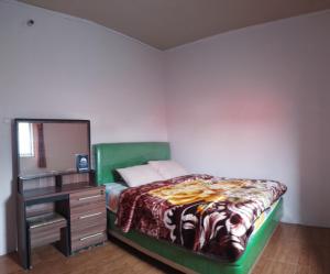 ein Schlafzimmer mit einem Bett und eine Kommode mit einem Spiegel in der Unterkunft Homestay wahyu abadi 2 syariah in Diyeng