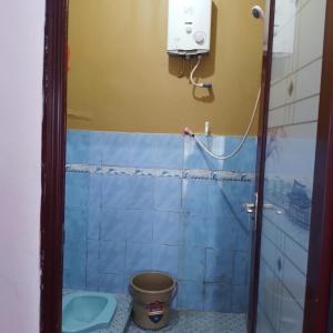 La salle de bains est pourvue de toilettes et d'un seau. dans l'établissement Homestay wahyu abadi 2 syariah, à Diyeng