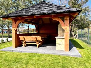 a wooden gazebo with a bench in the grass at Domki Yellow Hill Jastrzębia Góra in Jastrzębia Góra