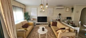 sala de estar con sofá y TV en Apartment Campoamor Descansa en Campoamor