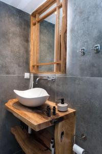 baño con lavabo blanco en una encimera de madera en Nikas Guest House en Kanálion