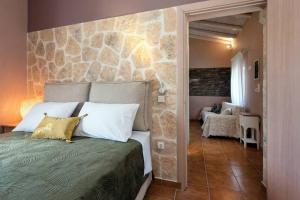 1 dormitorio con 1 cama con pared de piedra en Nikas Guest House en Kanálion